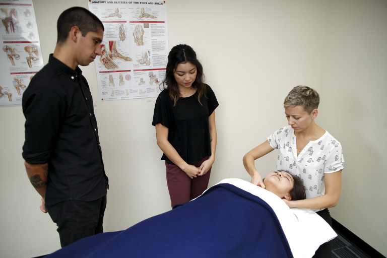 Emah Christiansen guiding for technique in a Massage Lab